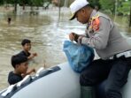 Anggota Satuan Lalu Lintas Polres Aceh Utara Membagikan Makanan kepada Korban Banjir